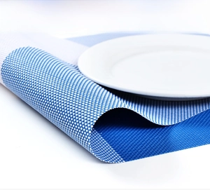 Macro view of blue and white woven PVC placemat showing flexibility and texture detail