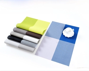 Close-up of woven PVC placemats in multiple colors with textured cross-weave detail