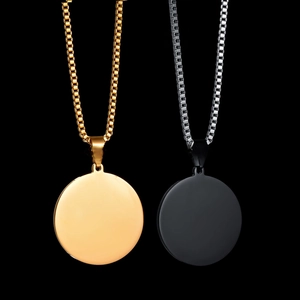 Polished gold and matte black stainless steel round pendants with box chains on black backdrop