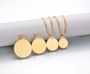 Close-up of polished gold-plated stainless steel round tags and necklace chains