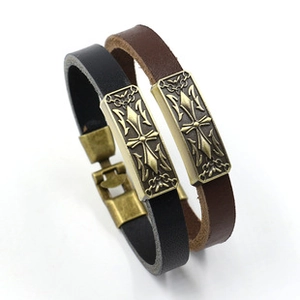 Close-up of black and brown leather bracelets with cross metal charms and textures