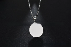 Polished round stainless steel blank pendant with classic square link chain on textured grey
