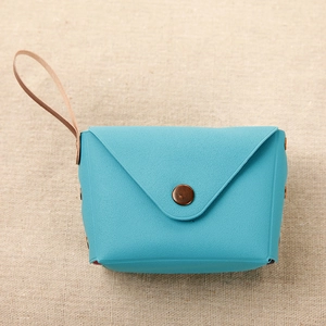 Detail view of sky blue coin purse with lychee grain texture and metal snap button