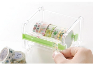 Clear acrylic tape dispenser with green rollers for organizing and cutting washi tapes