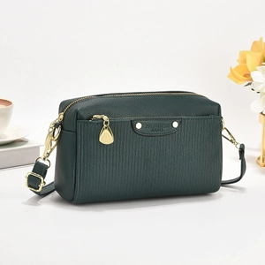 Sac bandoulière vert foncé à rayures avec détails dorés et gaufrage tendance sur fond blanc