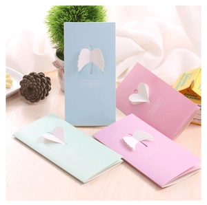 Macro shot of 3D angel wing greeting cards in pastel blue, pink, and mint green colors