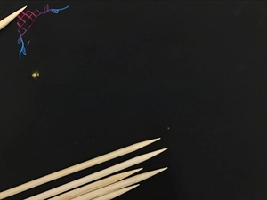 Detailed view of natural bamboo scratch art pen with sharp tip on black background