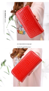 Dettaglio pochette lunga in vernice rossa con trama a coccodrillo e cerniera dorata