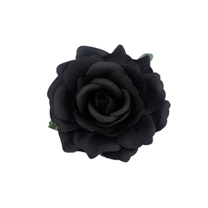 Close-up of black fabric rose hair clip with green leaves and multi-layered petals