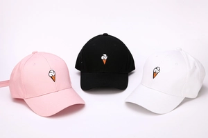 Detailed embroidery of ice cream cones on pink, black, and white baseball caps