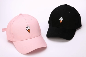 Close-up of ice cream embroidery detail on pink and black cotton baseball caps