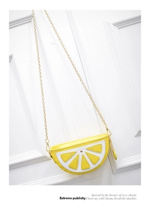 Close-up of lemon crossbody bag with yellow peel detail and thin metal chain strap