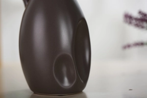 Detail van matbruine keramische vaas met minimalistische gestroomlijnde ergonomische groeven