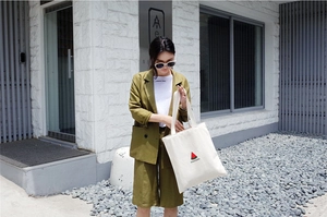 Streetstyle-Ansicht einer cremeweißen Canvas-Tragetasche mit Wassermelonen-Aufdruck