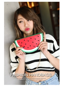 Detail shot of a semi-circular watermelon shaped handbag with gold chain and PU leather