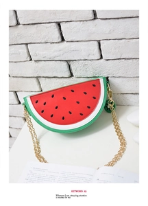 Detail of watermelon crossbody bag showing leather texture and gold chain strap