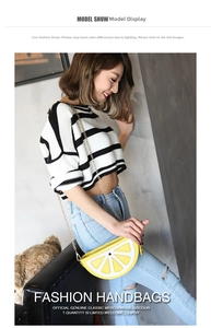 Model wearing a vibrant lemon-shaped crossbody bag with gold chain strap detail
