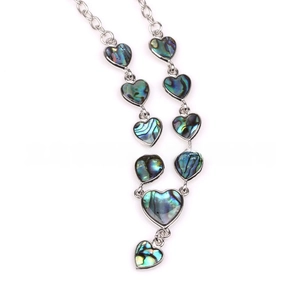 Detailed view of silver heart-shaped pendants with iridescent shell inlays on chain