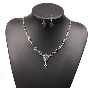 Detail of vintage teardrop abalone shell necklace and earrings set on a black bust display