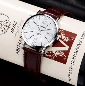 Macro shot of quartz watch with white Roman dial and brown leather strap on wine bottle