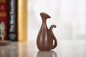Detail van een minimalistisch bruin keramisch kattenbeeldje met een matte afwerking decor