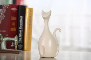 Close-up van minimalistisch keramisch kattenbeeldje met een elegante crème afwerking