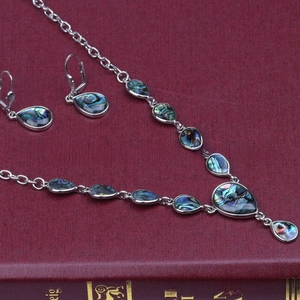 Detail of vintage necklace and earrings set featuring colorful abalone shell inlays