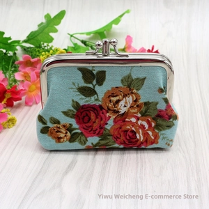 Detail of floral canvas coin purse with vintage rose pattern and silver metal clasp