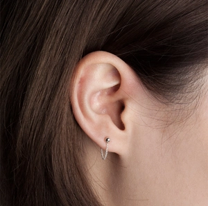 Detailed close-up of 925 sterling silver minimalist beaded tassel chain earrings on ear