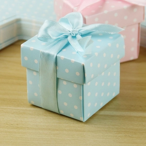 Detailed view of light blue polka dot favor box with decorative satin ribbon bow