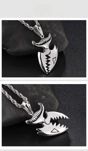 Macro detail of silver mechanical crocodile tooth pendant with rope chain on dark stone