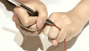 Macro view of measuring finger circumference with red string for silver ring size