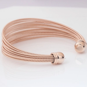 Detailed close-up of rose gold twisted cable cuff bangle with polished ball ends