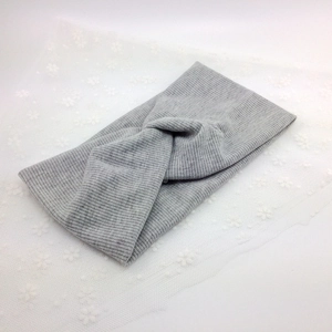 Detail of light grey ribbed knit headband featuring a stylish cross-twist design