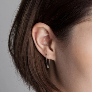 Close-up of minimalist 925 sterling silver ball stud earring with elegant chain tassel