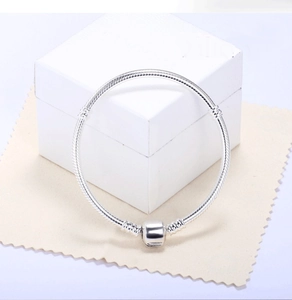 Detailed close-up of 3mm silver snake chain bracelet with barrel clasp on gift box
