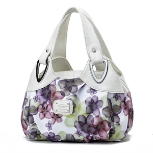 Detailed view of women's handbag featuring purple floral print and silver metal accents