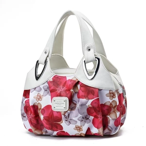 Close-up of white leather and floral fabric patchwork handbag with silver metal plate