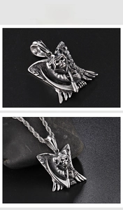Détail macro du pendentif crâne faucheuse gothique et gravure d'aile sur chaîne argent