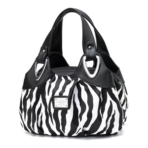 Detail of zebra print patchwork tote bag with metallic hardware and dual handles