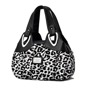 Chic black and white leopard print handbag with leather top and silver U-shaped metal rings