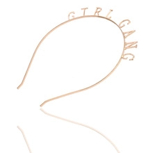Détail du serre-tête en métal doré avec l'inscription minimaliste GIRL GANG
