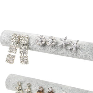 Elegant two-tier grey velvet jewelry stand displaying sparkling silver rhinestone earrings