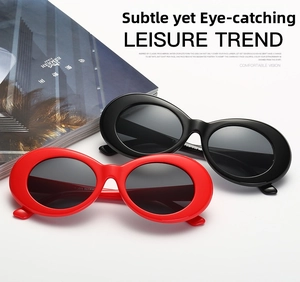 Detail view of vintage oval sunglasses in black and red colors on minimalist backdrop