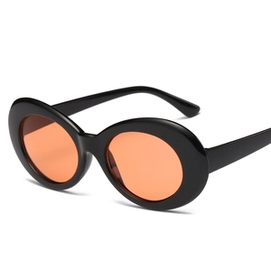 Detailansicht der ovalen Retro-Sonnenbrille mit dickem schwarzen Rahmen und orangefarbenen Gläsern