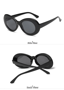 Detail view of vintage oval sunglasses with sleek black frame and grey lenses