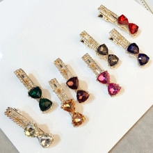 Primo piano di fermagli in lega con strass triangolari colorati in varie tonalità vivaci