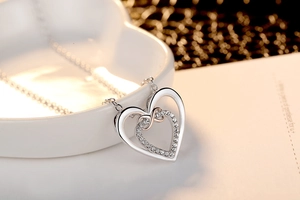 Close-up of dual-tone silver and rose gold heart necklace with sparkling crystals