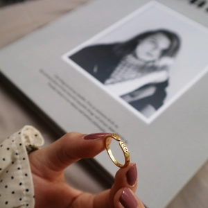 Detail of adjustable gold ring with geometric V-shaped textures and minimalist design