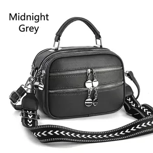 Midnight grey crossbody bag with pebble grain leather texture and woven shoulder strap